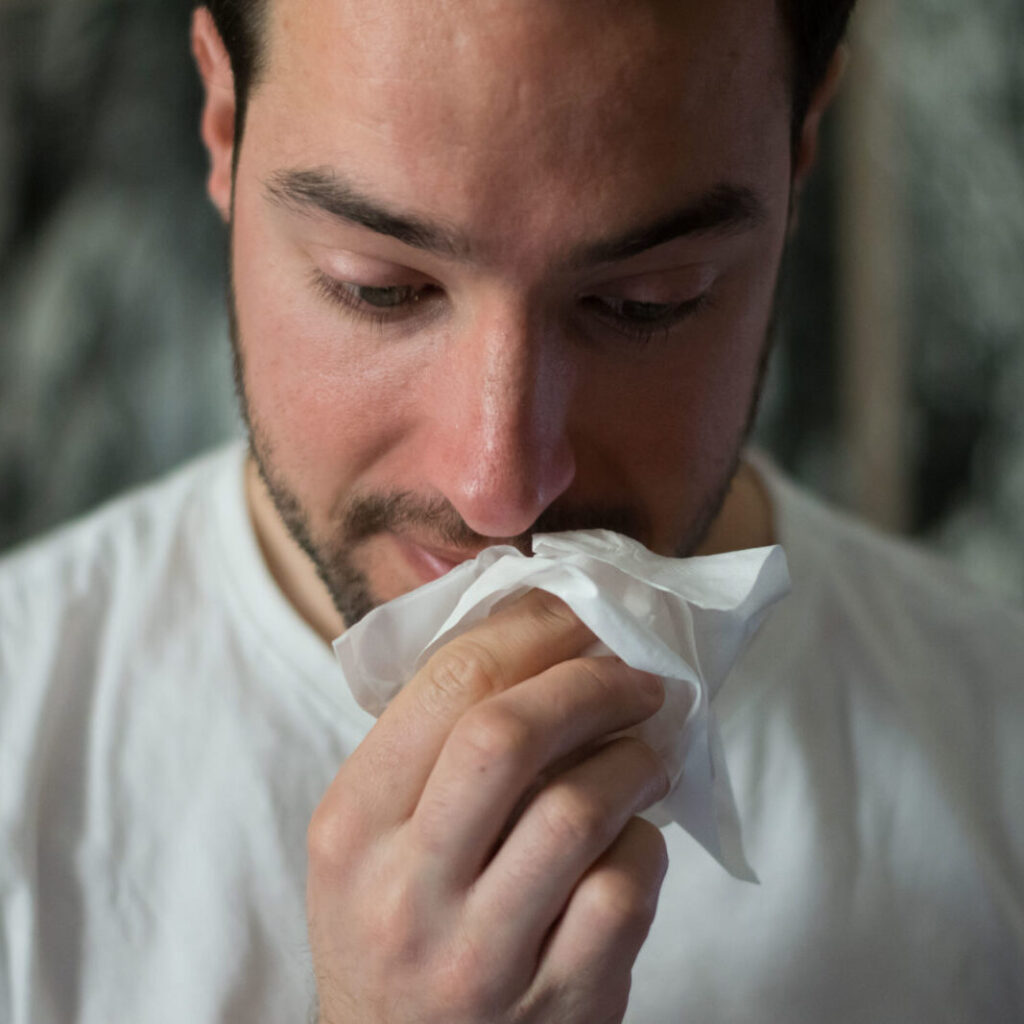 Ein junger Mann hält ein Taschentuch in der Hand. Es scheint als trockne er sich gleich eine Freudenträne.